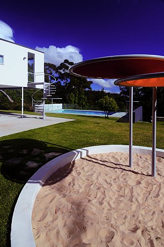 Detail view of sandpit with new parasol and pool beyond